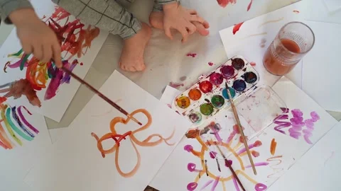Little boy of two years old draws with paints sitting on the floor Stock Footage 168093077