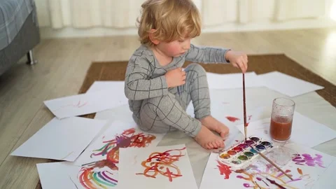 Little boy of two years old draws with paints sitting on the floor Stock Footage 168093231
