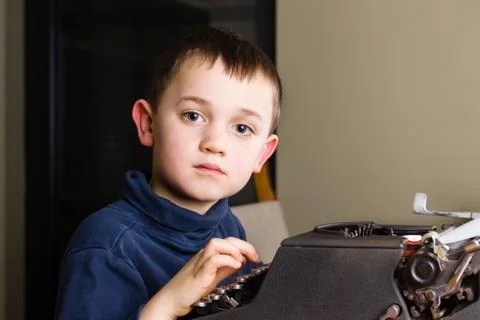 Little boy typing on old typewriter Stock Photos