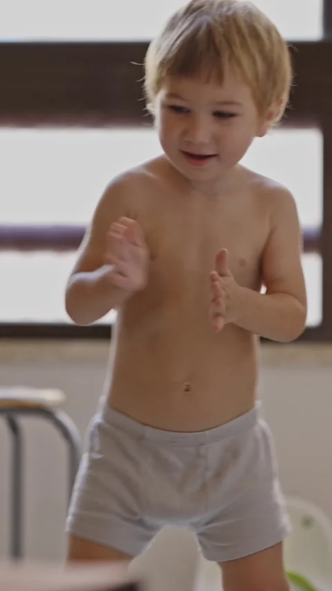 Little boy in underpants dancing and clapping his hands in the kitchen Stock Footage 329547947
