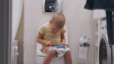 Little Boy Uses Tablet While on Toilet Vidéo 300752305