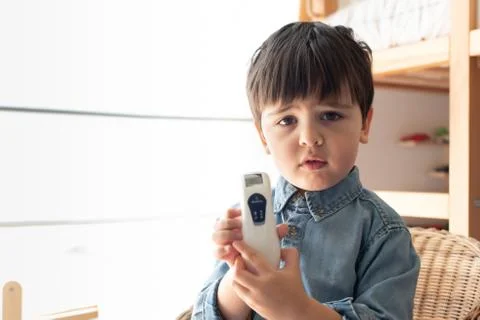 Little boy using a digital thermometer Stock Photos