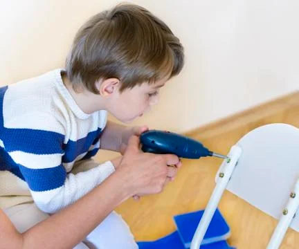 Little boy using diy tool being helped by parent Foto stock