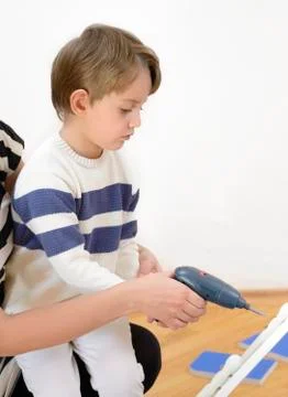 Little Boy using diy tool being helped by parent Stock Photos