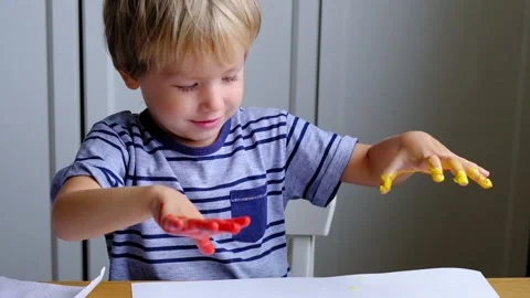 Little boy using finger paints with joy Vídeo Stock 95573328