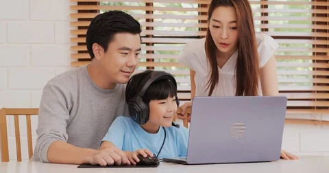 Little boy using laptop to play online game with his family. Vídeos de archivo 129892276