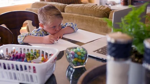 Little Boy Using A Laptop While Drawing Stock Footage 129499605