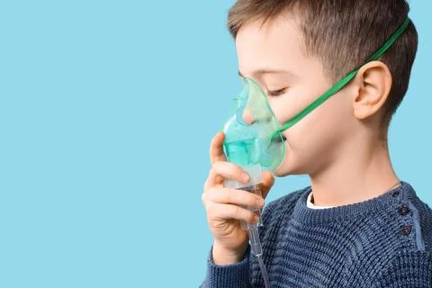 Little boy using nebulizer on blue background, closeup Stock Photos