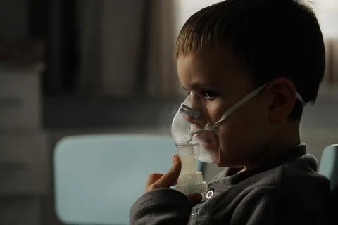 Little boy using nebulizer during inhaling therapy at home Stock Photos