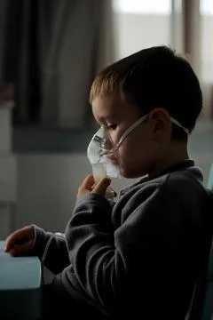 Little boy using nebulizer during inhaling therapy at home Stock-Fotos
