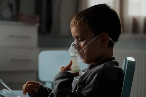 Little boy using nebulizer during inhaling therapy at home Foto stock
