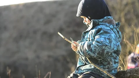 Little boy using a real sharp knife to sharpen a wooden stick. Real life play Stock Footage 170697963