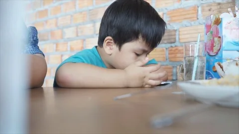 Little boy using smartphone, watching the movie and refusing the food. 스톡 동영상 75820354