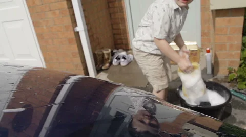 A little boy using sponge to wash his parents car Stock Footage 60225620