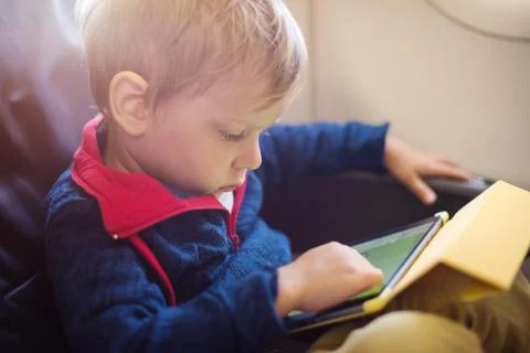Little boy using tablet on board of aircraft Foto stock