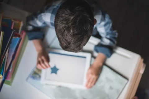 Little boy is using a tablet. Top view. Stock Photos
