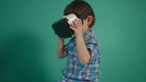 Little boy using virtual reality device over green wall Stock Footage 70839761