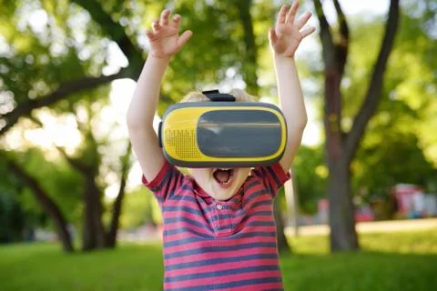 Little boy using virtual reality headset outdoor. VR, VR glasses, augmented r Stock Photos