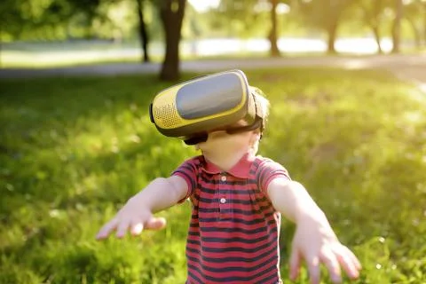 Little boy using virtual reality headset outdoor. VR, VR glasses, augmented r Foto stock