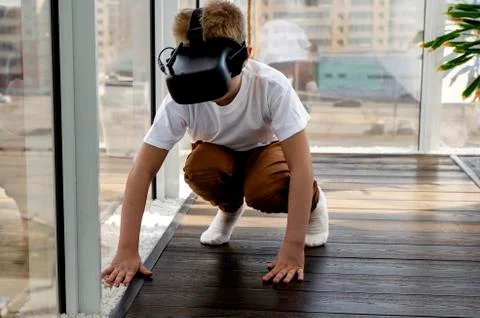 Little boy using a VR headset to play fighting game. Child with virtual reali Stock Photos