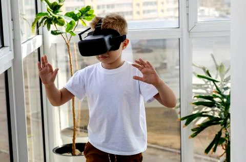 Little boy using a VR headset to play fighting game. Child with virtual reali Stock Photos