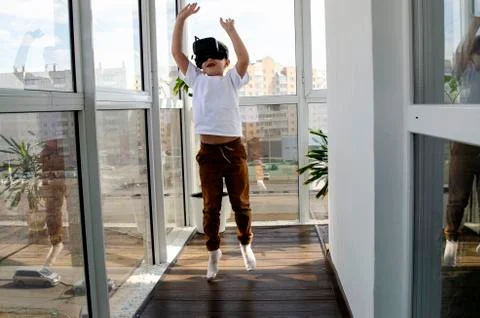 Little boy using a VR headset to play fighting game. Child with virtual reali Stock Photos