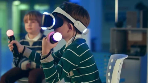 Little boy in vr headset playing virual reality game with controllers while 動画素材 76859048