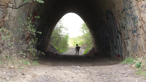 Little boy walking through stone tunnel Stock Footage 317334637