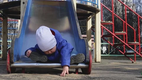 A little boy walks in the playground in the spring Stock Footage 152409321