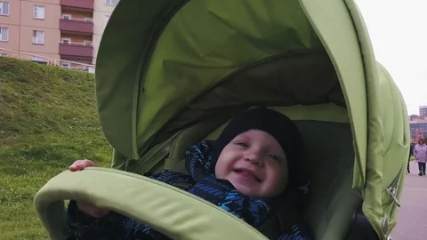 A little boy in warm clothes is riding in a pram. Stock Footage 81333686