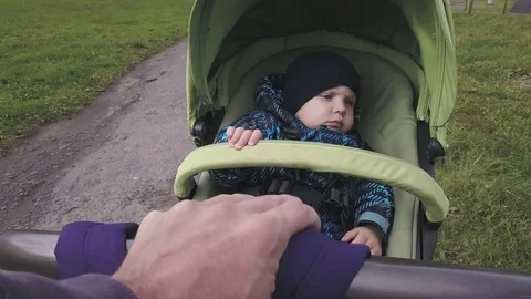 A little boy in warm clothes is riding in a stroller. Stock Footage 81345982