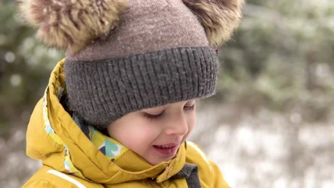 A little boy in a warm hat drinks hot tea from a cup outdoors in winter, steam Stock-Footage 144350772