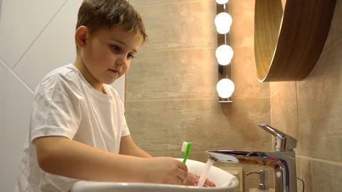 A little boy washes in the bathroom, side view Video stock 128778964