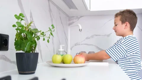 A little boy washes fruit under tap water. Healthy lifestyle. Personal hygiene Stock-Footage 213034291