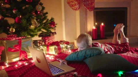 Little boy watching cartoons on notebook on New Years night Stock Footage 73016922