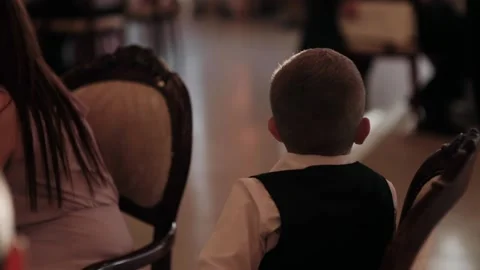  little boy watching while sitting at the table at the banquet Stock Footage 146849074