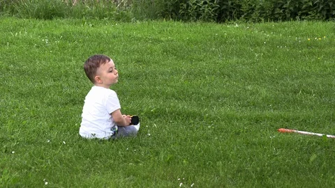 A little boy in a white hat plays a field flower field 库存影片 111693971
