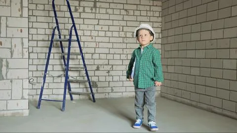 A little boy in a white helmet with documents in his hands Stock Photos