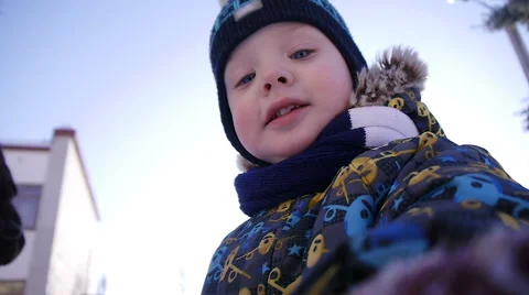 Little boy in a winter cap playing in the snow Stock Footage 61302530
