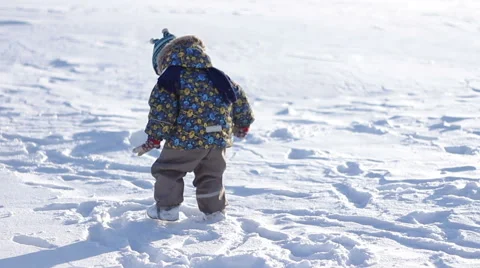 Little boy in a winter cap playing in the snow Stock Footage 61303447