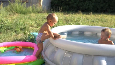 A little boys is playing in inflatable pools with water. Summer and holidays. Stock Footage 114317633