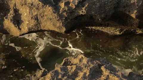 Little breaking waves through rocks Stock Footage 79218066