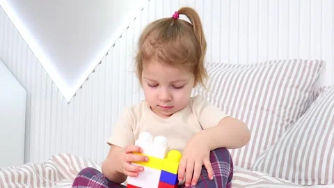 Little builder exploring creativity with colorful blocks in a cozy space Stock-Footage 295352699