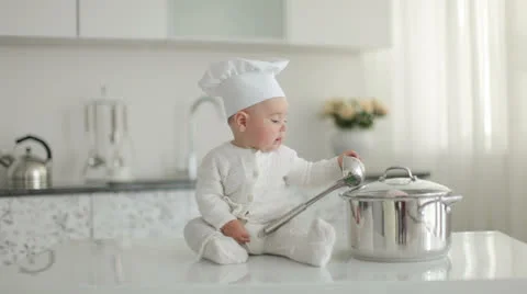 Little chef with a ladle knocking over a pan and laughs Stock Footage 23740868