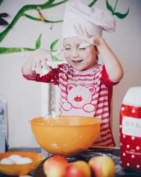 Little chef in the process of preparing a cake Stock Photos
