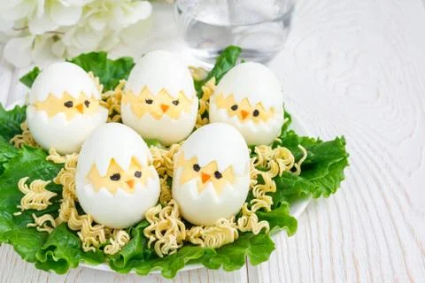 Little chicken in nest, deviled eggs served with salad and dry ramen on whi.. 스톡 사진