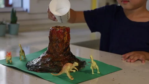 A little child is adding a reagent for volcanic eruption. Home education. Stock Footage 166040362