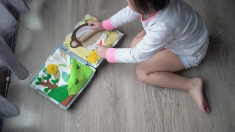 Little child brushing monkey teeth on montessori book toy Stock Footage 159125856