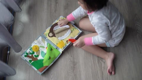 Little child brushing monkey teeth on montessori book toy Stock Footage 159125922