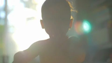 Little child clapping hands, view against the sunlight at home Stock Footage 100826946